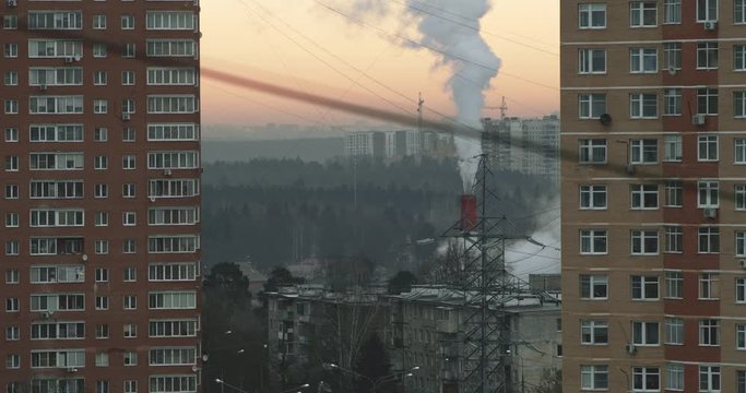 Russian town - Troitsk. Houses, power lines with wires and steam coming from the pipe on sunrise in the morning