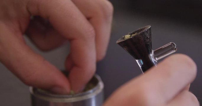 Close Up - Cannabis is packed from a grinder and into a bong bowl - shot on RED