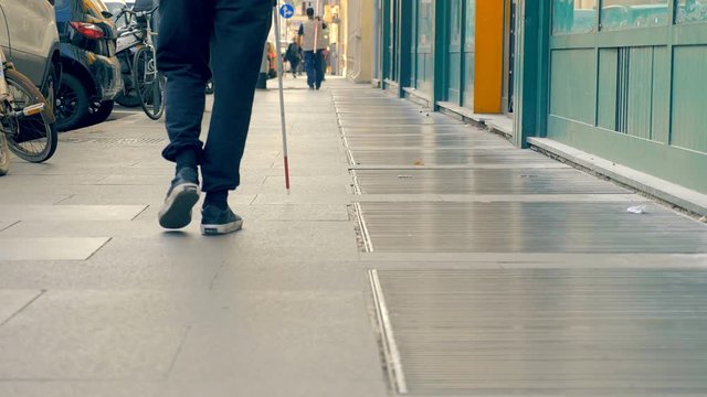 blind man walking alone on side walk in the city.Blindness,indipendent, autonomy