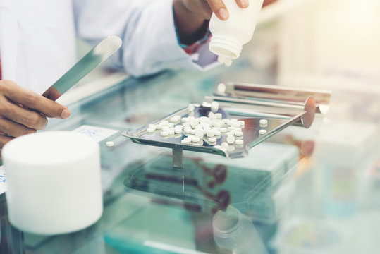 Medicine tablets on counting tray with counting spatula at pharmacy