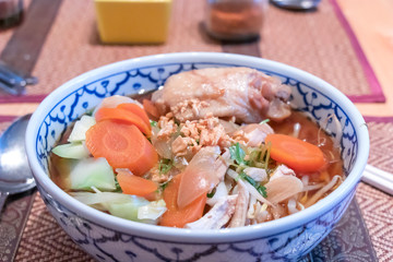 close up of Thai chicken noodles soup with carrot,bean sprouts,green vegetables and chili for more spicy. 