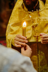 Holding a candle in prayer inside a Christian Orthodox church