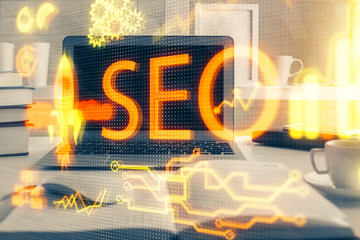 Multi exposure of table with computer and seo drawing hologram. Search optimization concept.