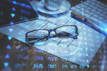 Financial chart hologram with glasses on the table background. Concept of business. Double exposure.