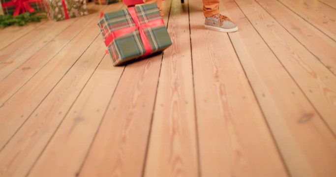 Young boy is smashing Christmas present to the ground and kicking it away