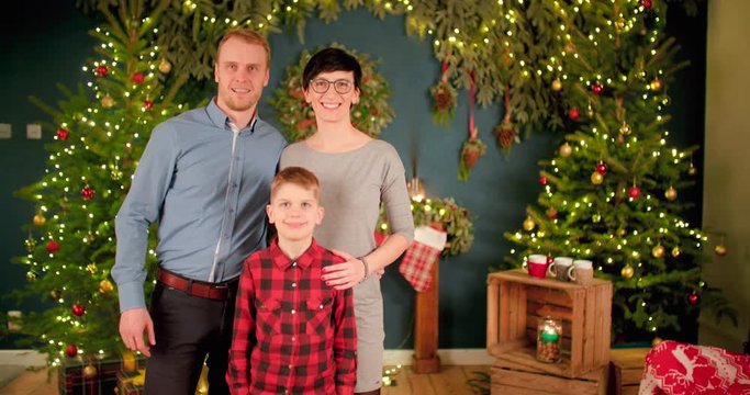 Family taking Christmas picture in decorated living room when father is rushing towards the camera