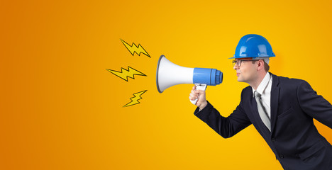 Fototapeta premium Young architect constructor yelling with megaphone and copyspace