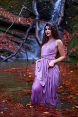 Fototapeta na wymiar Young latin woman by a waterfall