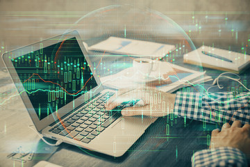 Double exposure of forex chart with man working on computer on background. Concept of market analysis.