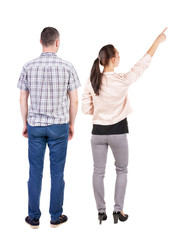 Back view of a stylish couple pointing.