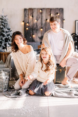 Christmas and new year theme. Parents and children at home playing with fake snow. Laughing joyful & emotions. Christmas 2019.