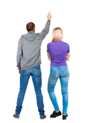 Back view of a stylish couple pointing.