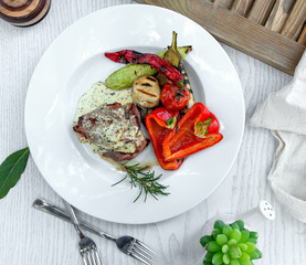 fried meat in a creamy sauce with baked vegetables