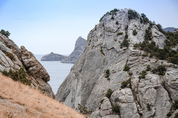 Mountain landscape by the sea. Travel to the sea, rock steep slope and mountain vegetation.