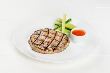 Grilled cutlet on a white plate shot isolated on a white background