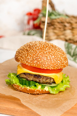 Cheeseburger pierced by a wooden skewer shot on a wooden board
