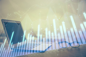 Stock market graph and table with computer background. Double exposure. Concept of financial...
