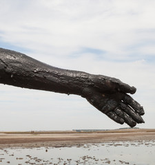 Woman's hand smeared with black healing mud.