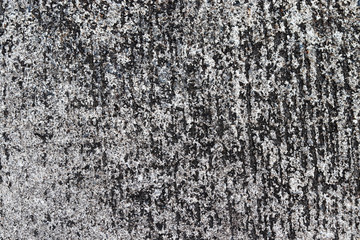 The wall is old and dirty, has a rough surface