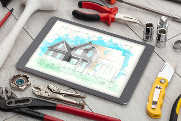 Tablet with construction tools and house plan concept
