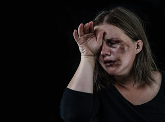 Crying woman victim of domestic violence and abuse. Isolated on dark background. Empty space for text
