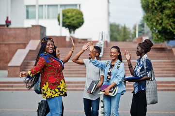 Group of five african college students spending time together on campus at university yard. Black afro friends studying and gives high five each other.