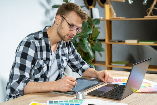 Young adult man working with graphic tablet in office