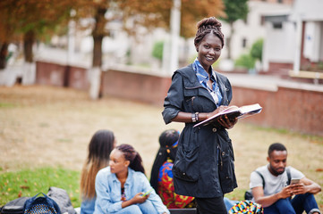 Group of five african college students spending time together on campus at university yard. Black afro friends studying. Education theme.