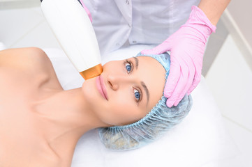 Anti-aging procedures. Skin care concept. Woman receiving facial beauty treatment, removing...