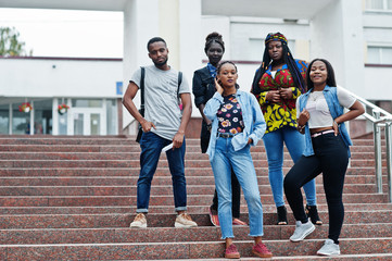 Fototapeta premium Group of five african college students spending time together on campus at university yard. Black afro friends studying. Education theme.