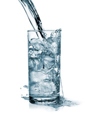 Water pouring in a glass with ice