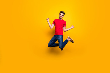 Fototapeta na wymiar Full size photo of cheerful content guy jump win lottery raise fists wear casual style clothes isolated over yellow color background