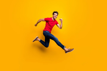 Fototapeta na wymiar Full length photo of cheerful youth guy jump have fun on spring time holidays wear casual style clothing isolated over yellow color background