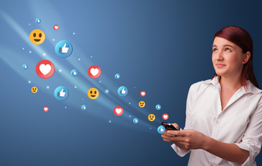 Young person using smartphone with flying social media icons around