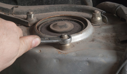 unscrewing the bolt on the car