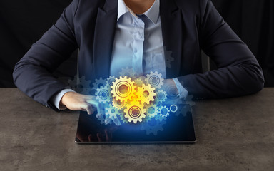 Business woman working on tablet with setting and gear concept