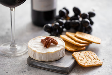 Red wine and charcuterie board with different snacks for wine. Cheese, grapes and crackers.