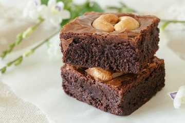 Homemade bakery dark chocolate fudge brownies cake topping with cashew nut and rosemary stacked on...