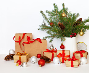 Beautiful Christmas still life with decorated Christmas tree branches, gifts in boxes and craft bags and New Year's toys on a white background. Copy space, close-up