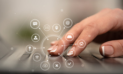 Business woman hand typing on keyboard with application icons around