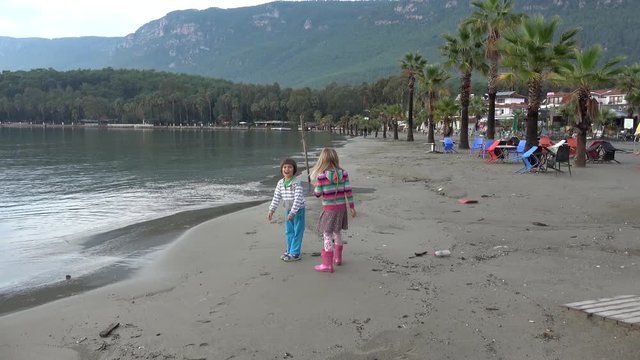 Akyaka, Mugla, Turkey - 12th of November 2019: 4K After rain beach and children collecting findings