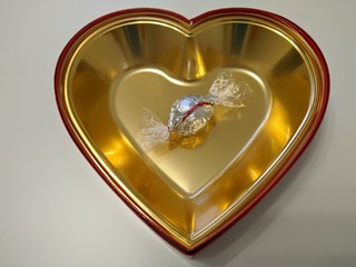 Silver candy on gold heart on white background