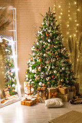 decorated for Christmas house. big beautiful spruce. beautiful Christmas room with lights and garlands. Christmas tree decoration, fireplace and sofas in a cozy room. Christmas Studio with wooden wall