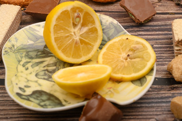 Fototapeta na wymiar sliced lemon on a saucer and on a wooden background. Close up.