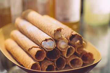 Wafer rolls filled with cream on a plate. Holiday desserts and treats for children