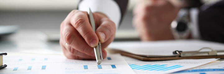 Male arm point silver pen at important paper