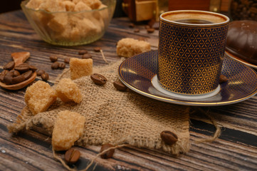 Coffee Cup, coffee beans, brown sugar on wooden background. Close up.
