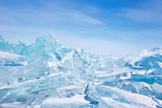 Baikal Lake. Beautiful blue ice hummocks on a background of blue sky on a sunny frosty day. Winter landscape. Natural cold background.
