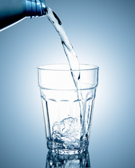 Pouring clean drinking water on a transparent glass. For health concepts. Isolated white background
