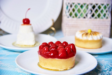 Cake with cherry on a decorated table.